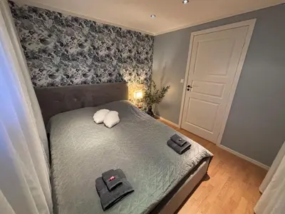 a bedroom with a bed with two towels on it at Cozy Apartment in Ålesund