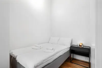 a small bed with white sheets and a night stand at Modern Apartment with Rooftop Terrace and Stunning Views in Bergen