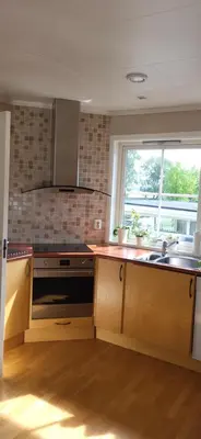 a kitchen with wooden cabinets and a sink and a window at Dalgårdveien 5 in Trondheim