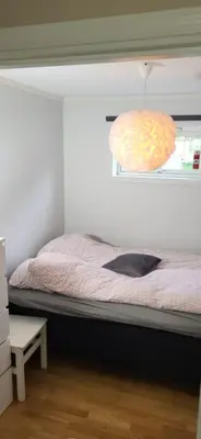 a bedroom with a bed with a window and a pillow at Dalgårdveien 5 in Trondheim