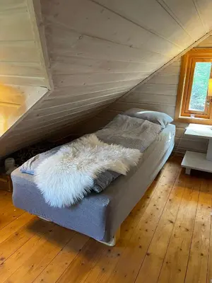 a bedroom with a bed in a attic at Hytte ved sjøen med båtutleige in Kvalsvik