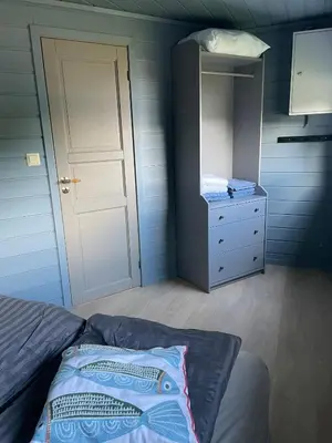 a bedroom with a bed and a dresser and a closet at Hytte ved sjøen med båtutleige in Kvalsvik