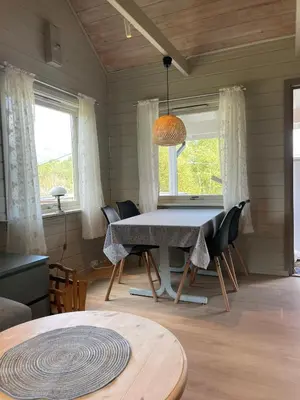 a dining room with a table and chairs at Hytte ved sjøen med båtutleige in Kvalsvik