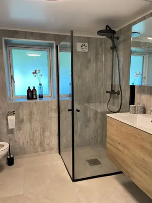 a bathroom with a shower and a toilet and a sink at Charming Modern Apartment Close to Moa & Ålesund in Ålesund