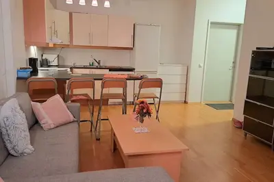 a living room with a couch and a table and a kitchen at Leilighet ved City Lade in Trondheim