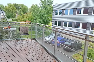 a balcony with a table and a car parked on it at Leilighet ved City Lade in Trondheim