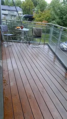 a deck with two chairs and a table on a balcony at Leilighet ved City Lade in Trondheim