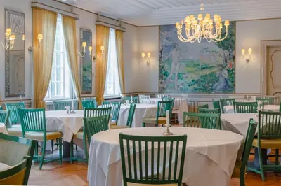 a dining room with tables and chairs and a chandelier at Orkla Gjestebolig in Løkken