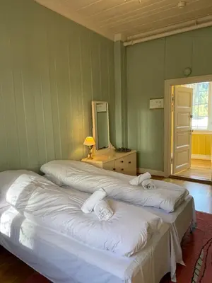 two beds in a room with a mirror at Orkla Gjestebolig in Løkken