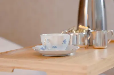 a cup and a saucer on a wooden table at Orkla Gjestebolig in Løkken