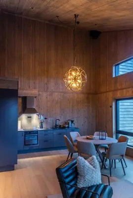 a living room with a table and a kitchen at Skistadion Hafjell in Hafjell