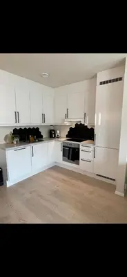 a large white kitchen with white cabinets and appliances at Rekkehus til SKI-VM in Lund