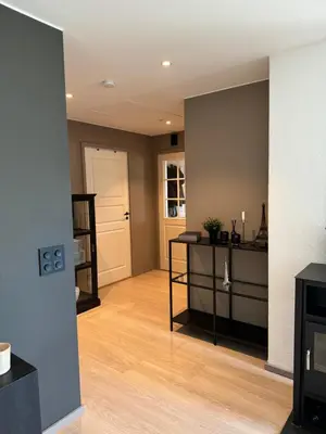 a living room with a wooden floor and a white door at Big 2 bedrooms apartment 10 min from Granåsen, VM2025 in Trondheim