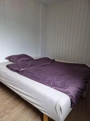 a bed with a purple comforter in a room at Trysil sentrum leilighet in Trysil
