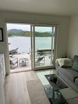 a living room with a view of the water at Amundøya Boathouse in Vadstensvik