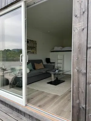 a sliding glass door leading to a living room at Amundøya Boathouse in Vadstensvik
