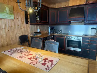 a kitchen with wooden cabinets and a wooden table at Cozy 3-Bedroom Apartment Near Beitostølen Ski in Beitostøl