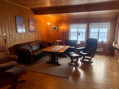 a living room with a couch and a table and chairs at Cozy 3-Bedroom Apartment Near Beitostølen Ski in Beitostøl
