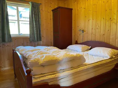 a bed in a wooden room with two pillows on it at Cozy 3-Bedroom Apartment Near Beitostølen Ski in Beitostøl