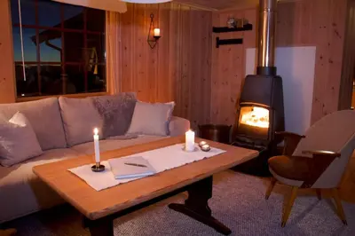 a living room with a couch and a wood stove at Koselig familiehytte på Rømåsen in Ringsaker