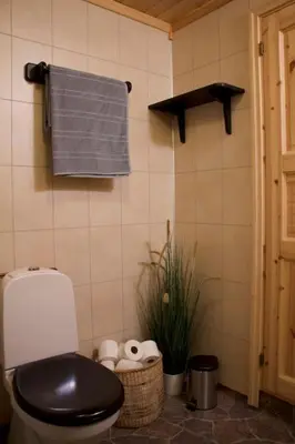 a bathroom with a toilet and a towel on the wall at Koselig familiehytte på Rømåsen in Ringsaker