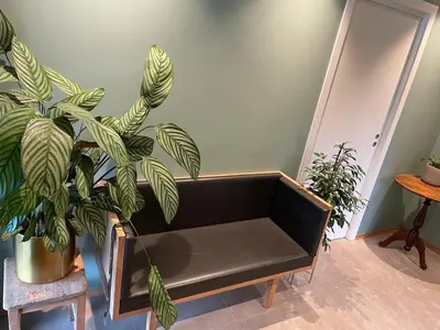 a black bench in a room with plants at Presthusvegen in Trondheim
