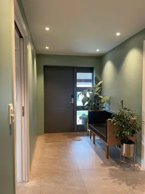 a hallway with a door with a bench and a plant at Presthusvegen in Trondheim