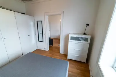 a white bedroom with a dresser and a mirror at Leilighet i Ålesund Sentrum in Ålesund