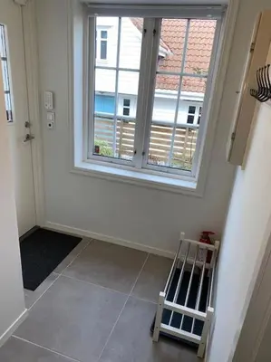 a room with a large window and a tiled floor at Moderne og fullt utstyrt 3-rom hageleilighet sentrum nær in Bergen