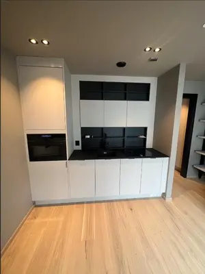 a kitchen with white cabinets and a wooden floor at midt i Lillehammer in Lillehammer