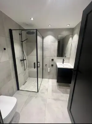 a bathroom with a shower and a toilet and a sink at midt i Lillehammer in Lillehammer