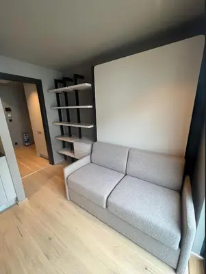 a living room with a couch and a book shelf at midt i Lillehammer in Lillehammer