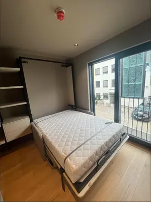 a bed in a room with a large window at midt i Lillehammer in Lillehammer