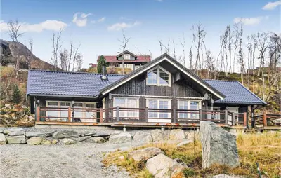 a large wooden house on top of a mountain at Nice Home In Straumgjerde With Wifi in Brunstad