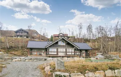 a large wooden house on top of a hill at Nice Home In Straumgjerde With Wifi in Brunstad