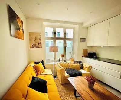 a living room with a yellow couch and a table at Downtown free parking cozy apartment in Ålesund