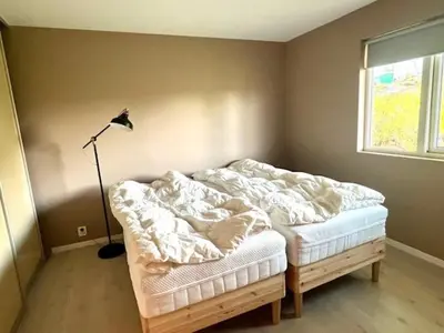 a bedroom with a bed and a lamp and a window at House close to World cup Trondheim 2025 in Trondheim