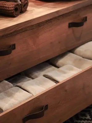 a wooden chest of drawers with cushions on it at Tømmerhus i Geiranger Sentrum med panorama utsikt in Geiranger