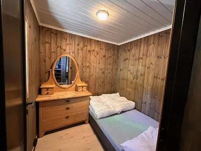 a small room with a bed and a mirror at Modern Cozy Cabin Near Langsua National Park in Heggenes