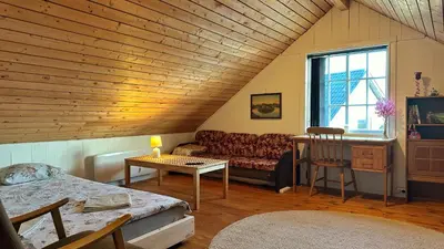 a living room with a couch and a table at Cozy Cabin in Volda
