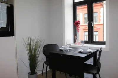 a black table and chairs in a room with a window at One-bedroom apartment close to NTNU and St Olavs in Trondheim