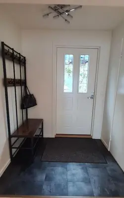 a room with a white door and a table and a fan at Villa with a view in Ålesund