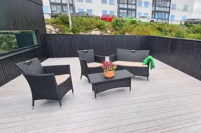 a patio with four chairs and a table and a table and chairs at Villa with a view in Ålesund