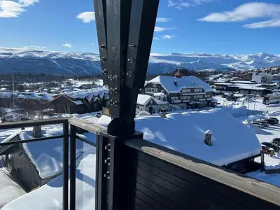 a balcony with snow on the roofs of houses at Riddertunets toppleilighet in Beitostøl