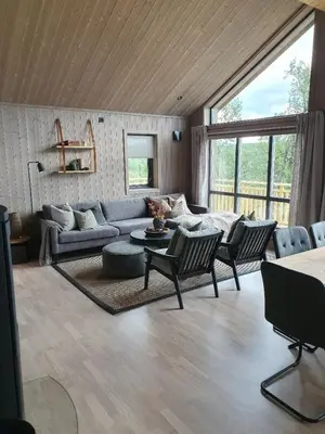 a living room with a couch and a table and chairs at NEUE Fjellhytte in Etnedal