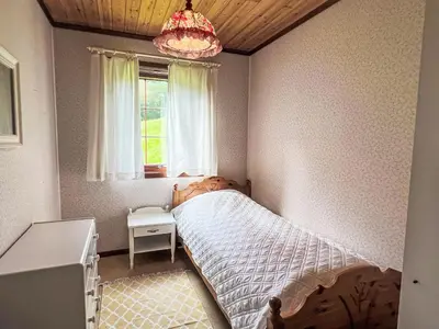 a bedroom with a bed and a window and a chandelier at Holiday Home Askelund by Interhome in Uggdal