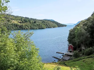 a large lake with a red house in the middle at Holiday Home Askelund by Interhome in Uggdal