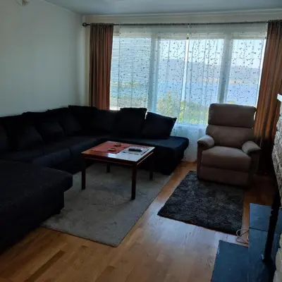 a living room with a couch and a table and a chair at Separate rooms in a large house,on the E6 road in Biri