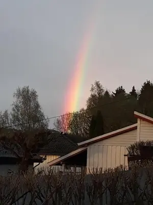 a rainbow in the sky over a building at Separate rooms in a large house,on the E6 road in Biri