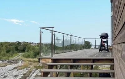 a wooden bridge with a grill on the side of a building at Nice Home In Lysøysundet With Wifi in Lysøysund